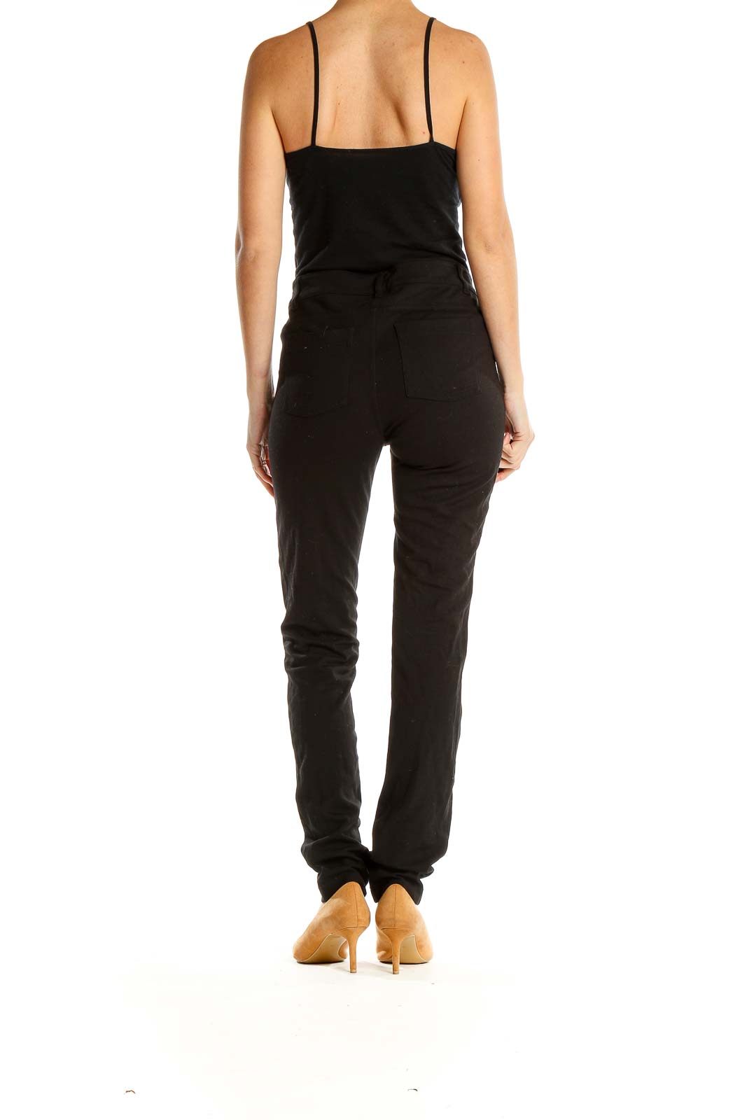 Side view of black Athleta slim-fit athletic pants on model with tan heels