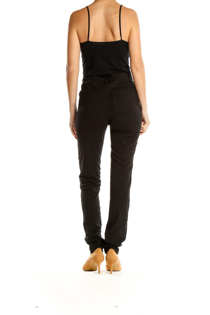 Side view of black Athleta slim-fit athletic pants on model with tan heels