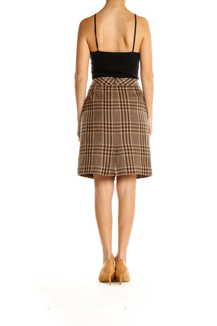 Side view of Ann Taylor brown plaid A-line skirt with black top