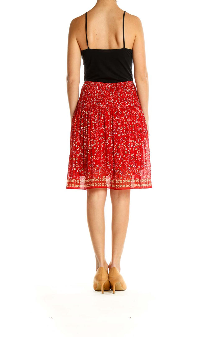 Side view of Max Studio red floral printed pleated midi skirt on model