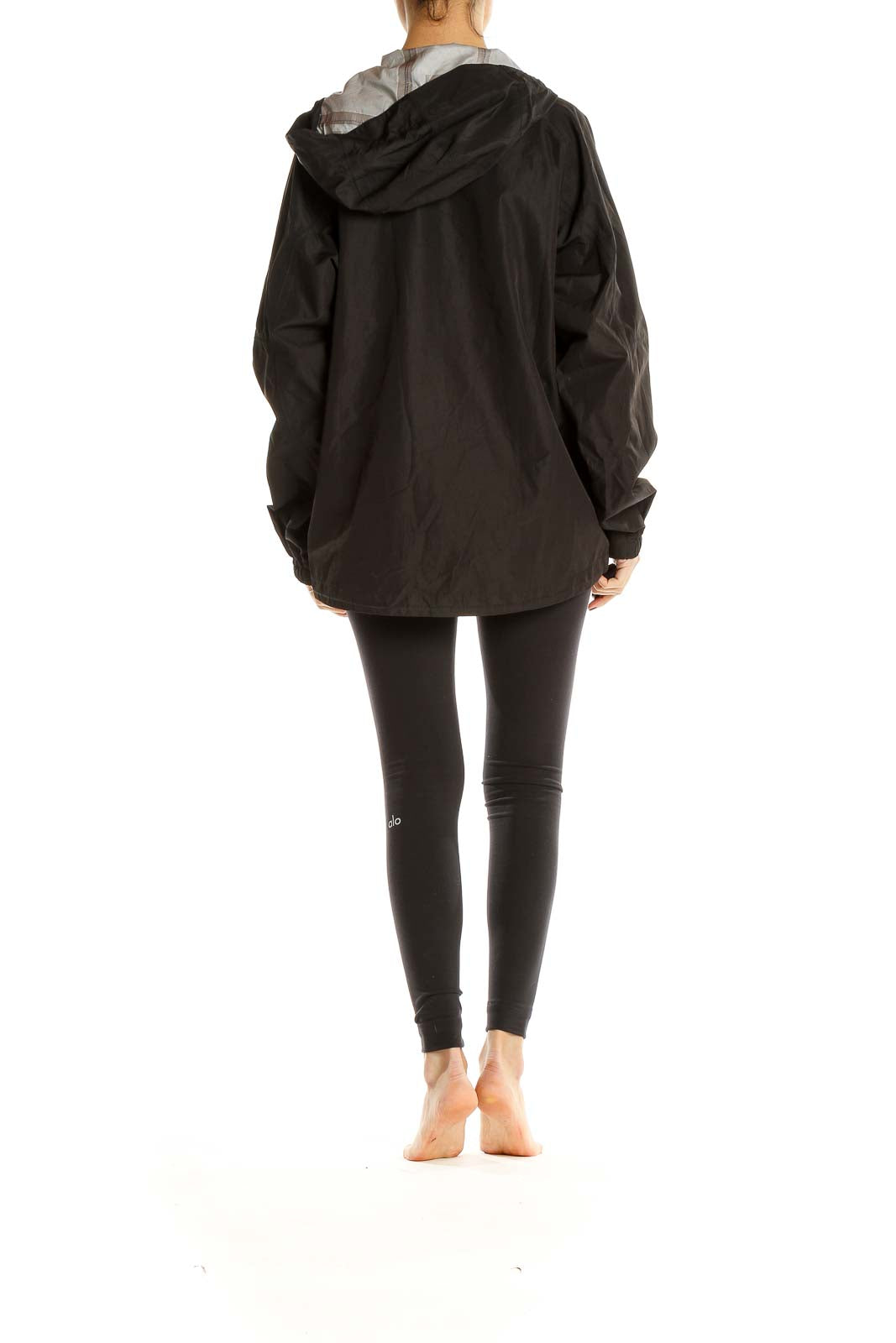 Side view of black L.L.Bean hooded rain jacket on model with leggings