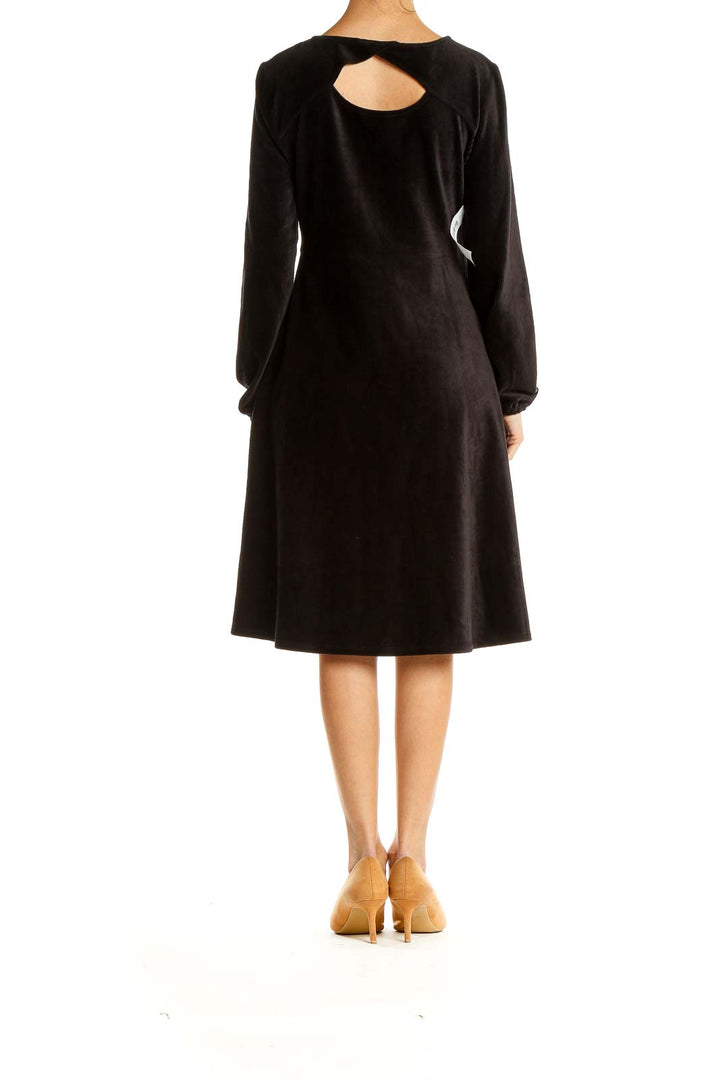 Side view of black Spense long sleeve midi dress showing flared skirt