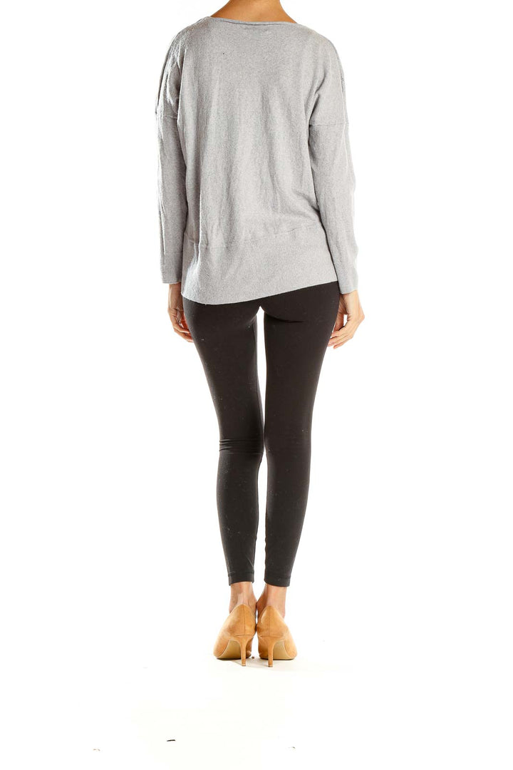 Side view of model wearing Cynthia Rowley gray ribbed knit sweater with black leggings