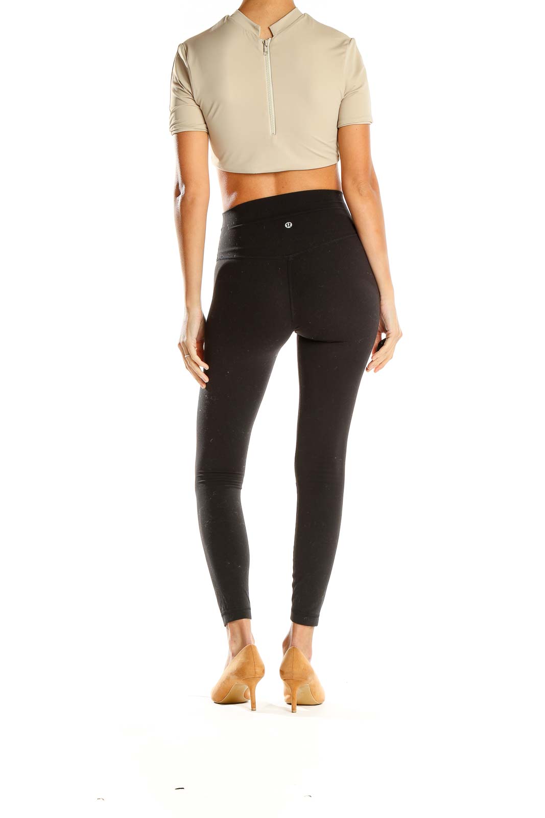 Side view of model wearing aexae beige cropped top with black leggings