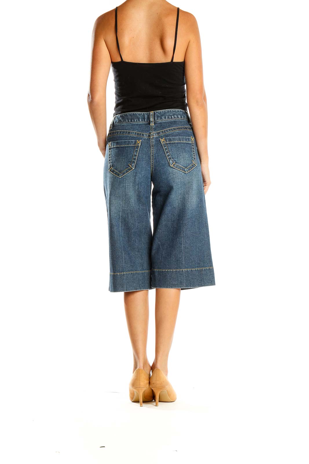 Side view of Ann Taylor LOFT Petites blue denim wide-leg cropped jeans on model