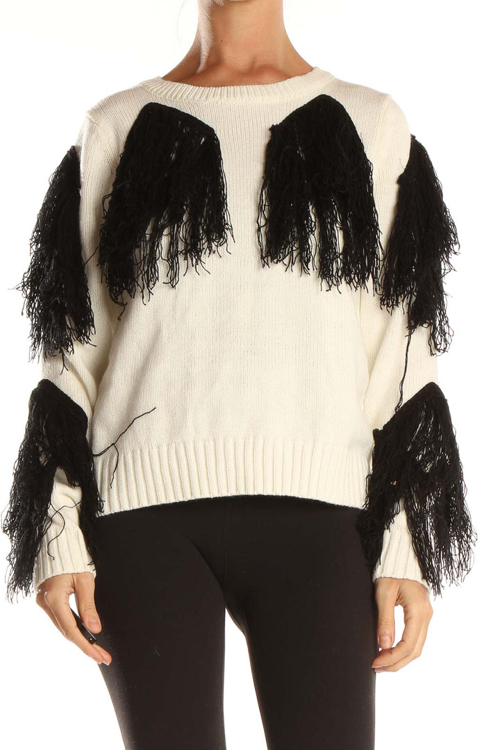 Front view of white knit sweater with black fringe detailing on sleeves and body