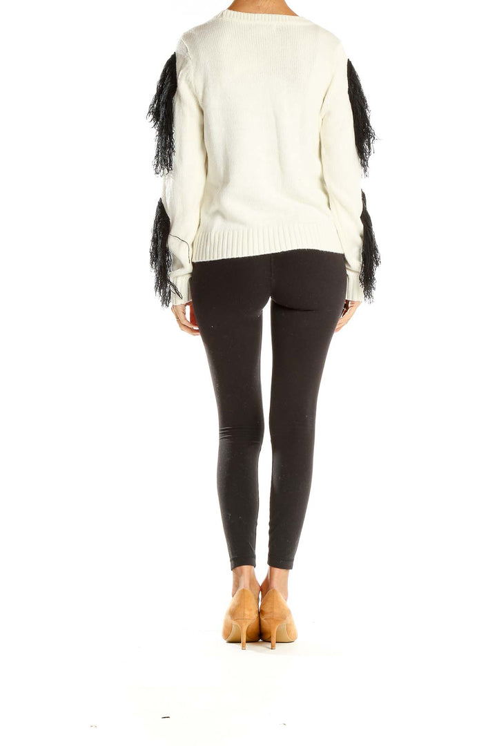 Back view of white knit sweater showcasing black fringe pattern and relaxed fit