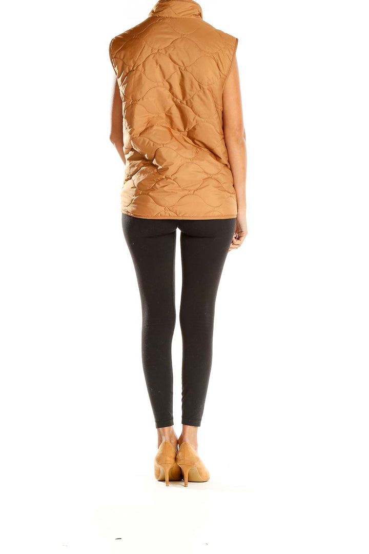 Side view of model wearing Croft & Barrow camel quilted puffer vest with black leggings