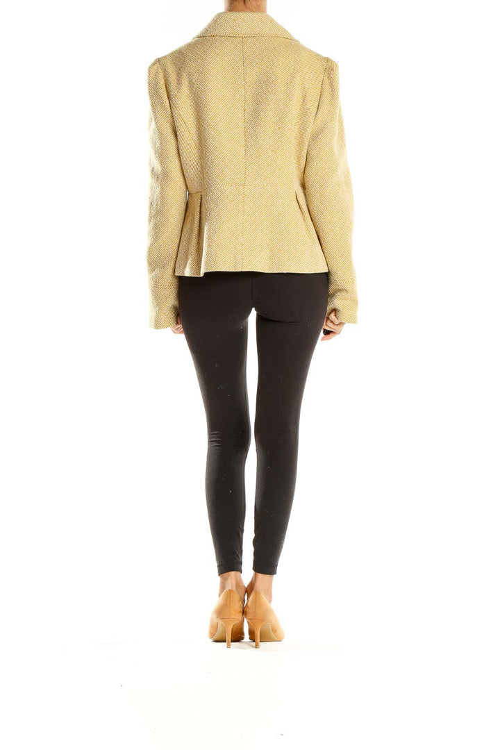 Side view of model wearing Tabitha beige textured jacket with black pants