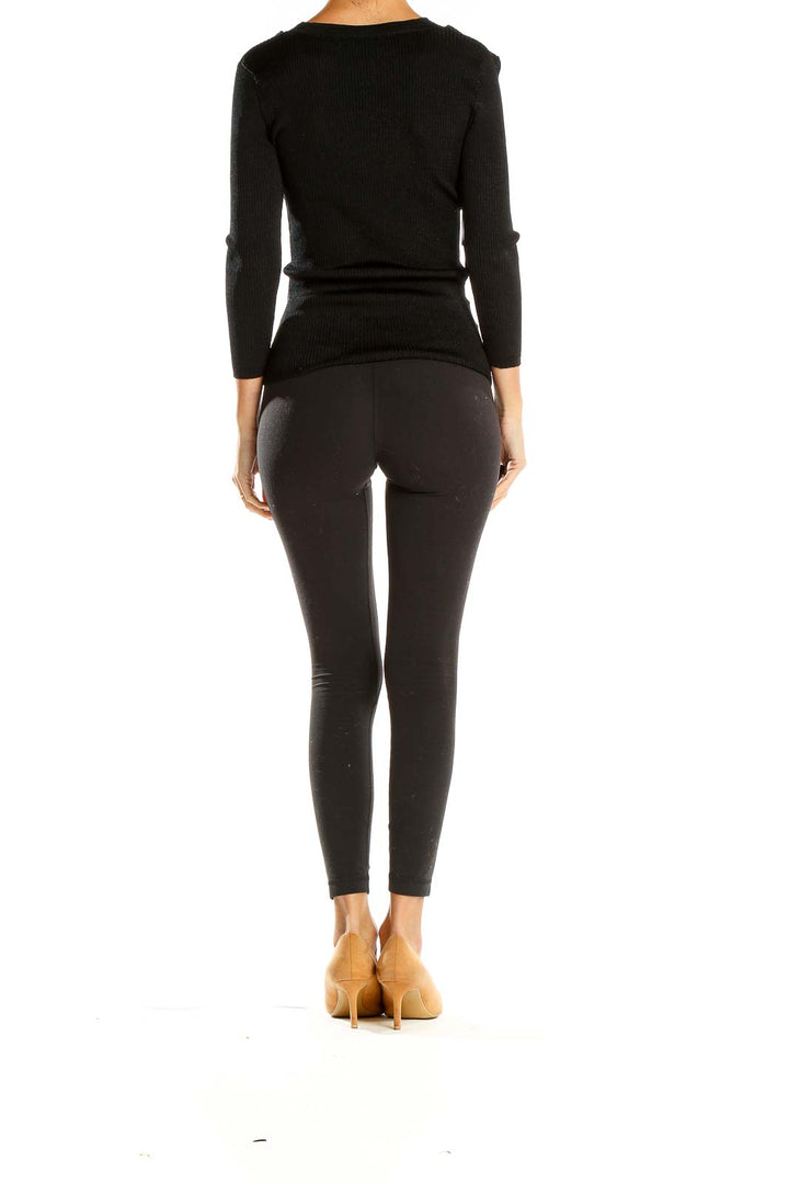 Side view of ICB black V-neck ribbed knit sweater on model with full outfit