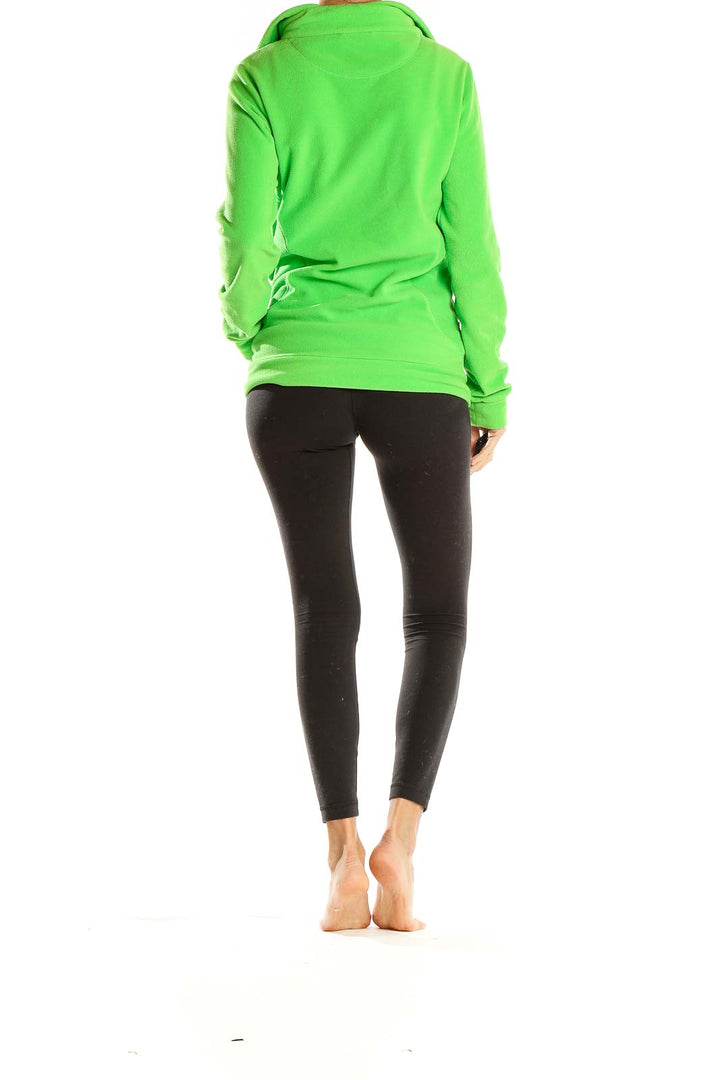 Side view of green Adidas fleece jacket with model wearing black leggings