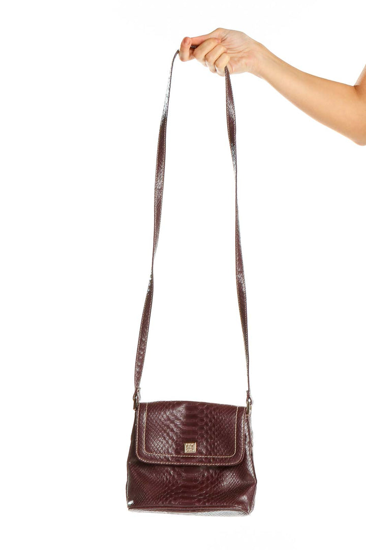 Front view of burgundy Liz Claiborne snakeskin textured crossbody bag