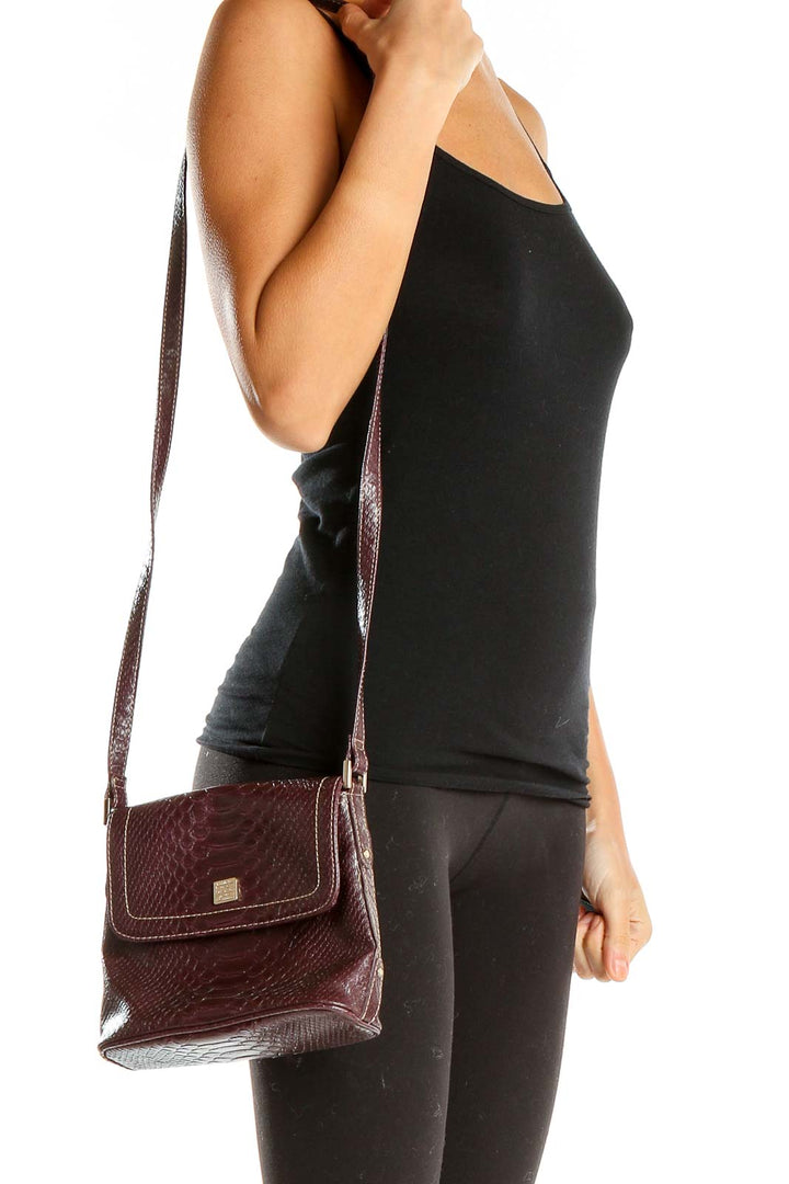 Front view of burgundy Liz Claiborne snakeskin textured crossbody bag