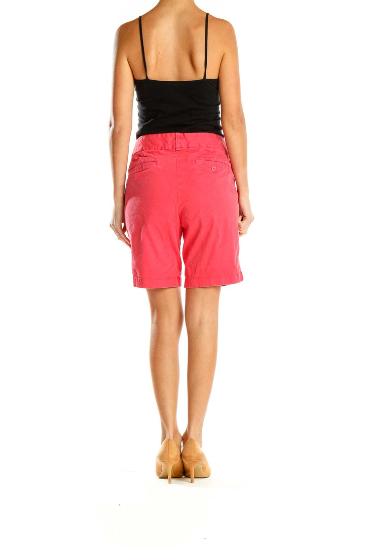 Side view of J.Crew coral chino shorts on model with black top
