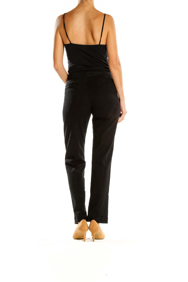 Side view of FRAME Denim black straight-leg pants on model