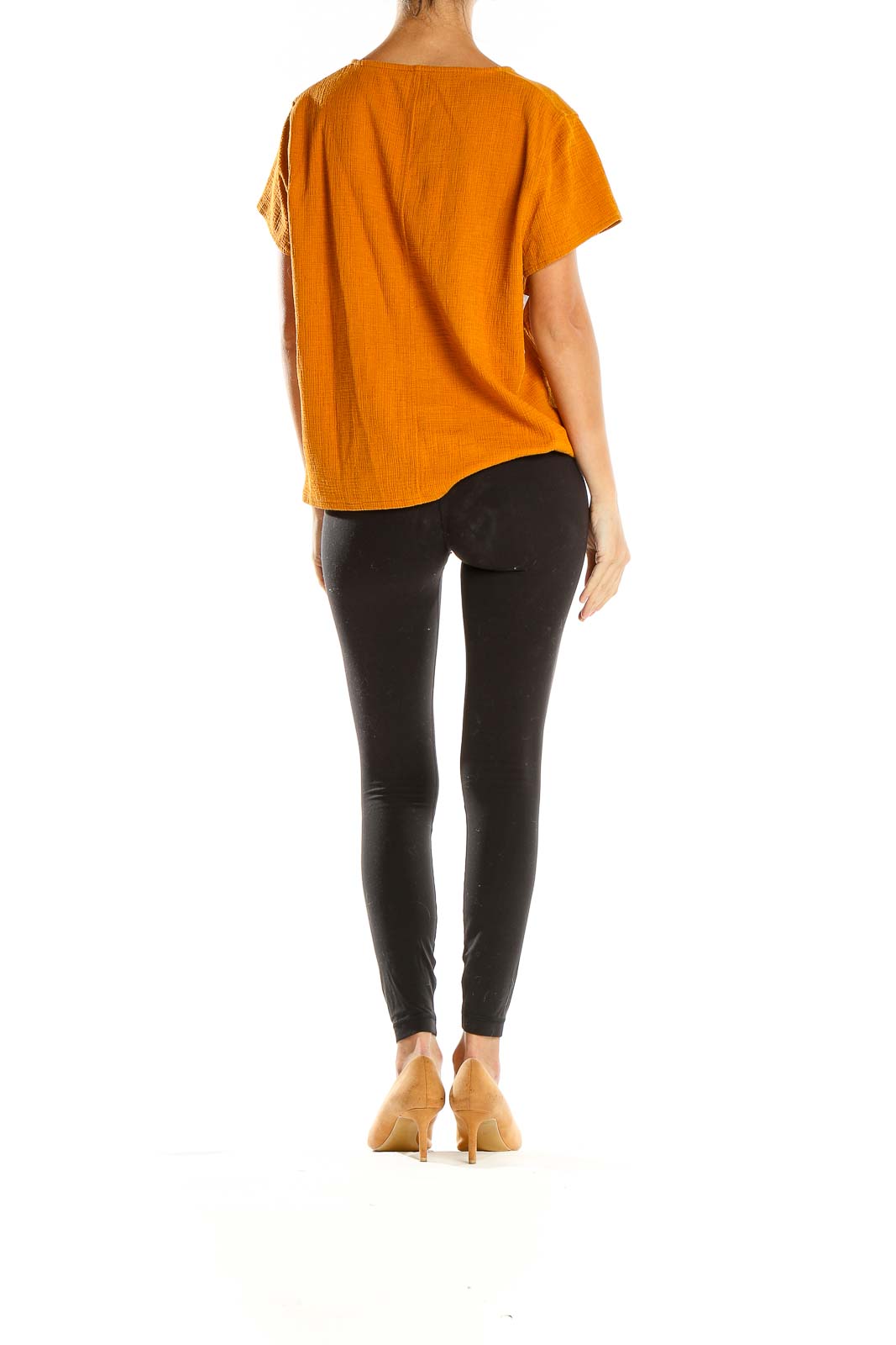Side view of orange J.Crew button-front top paired with black pants