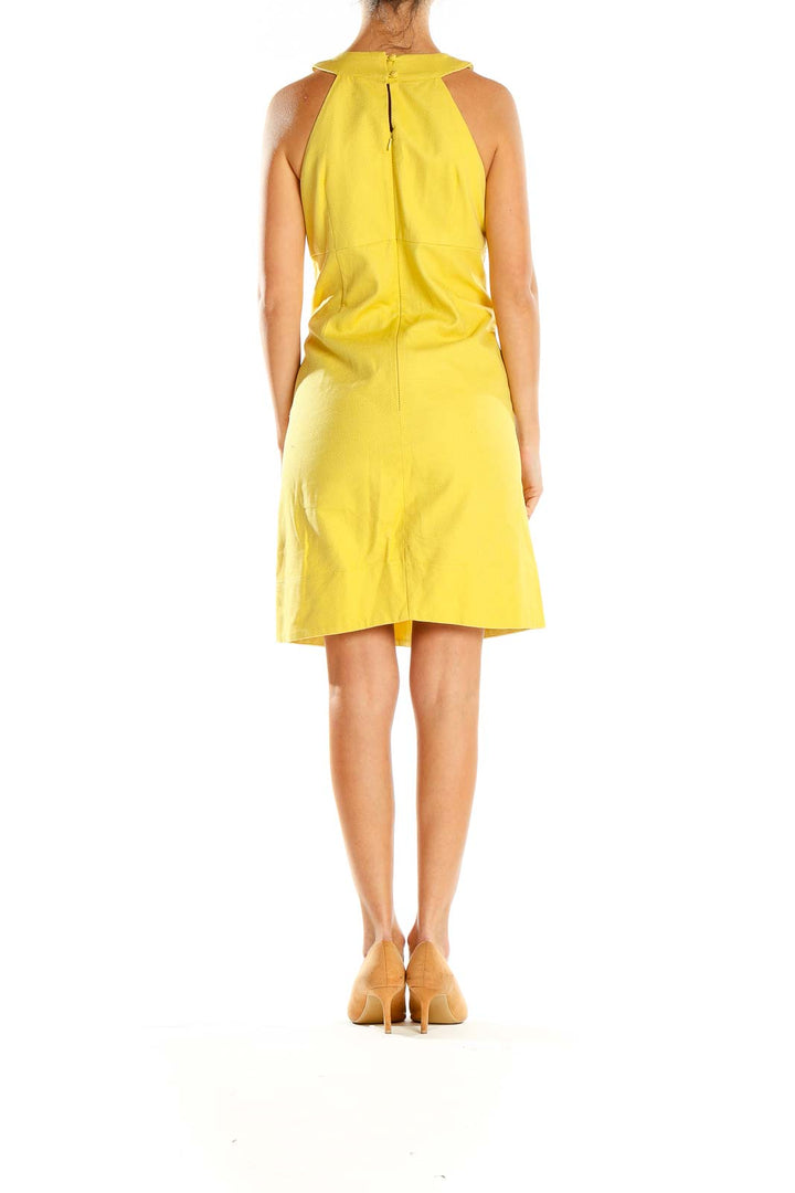 Side view of yellow INC halter neck dress showing A-line silhouette