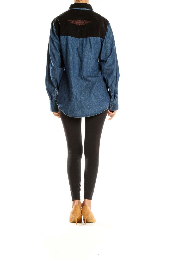 Side view of model wearing Harley Davidson blue denim western-style shirt with black leggings