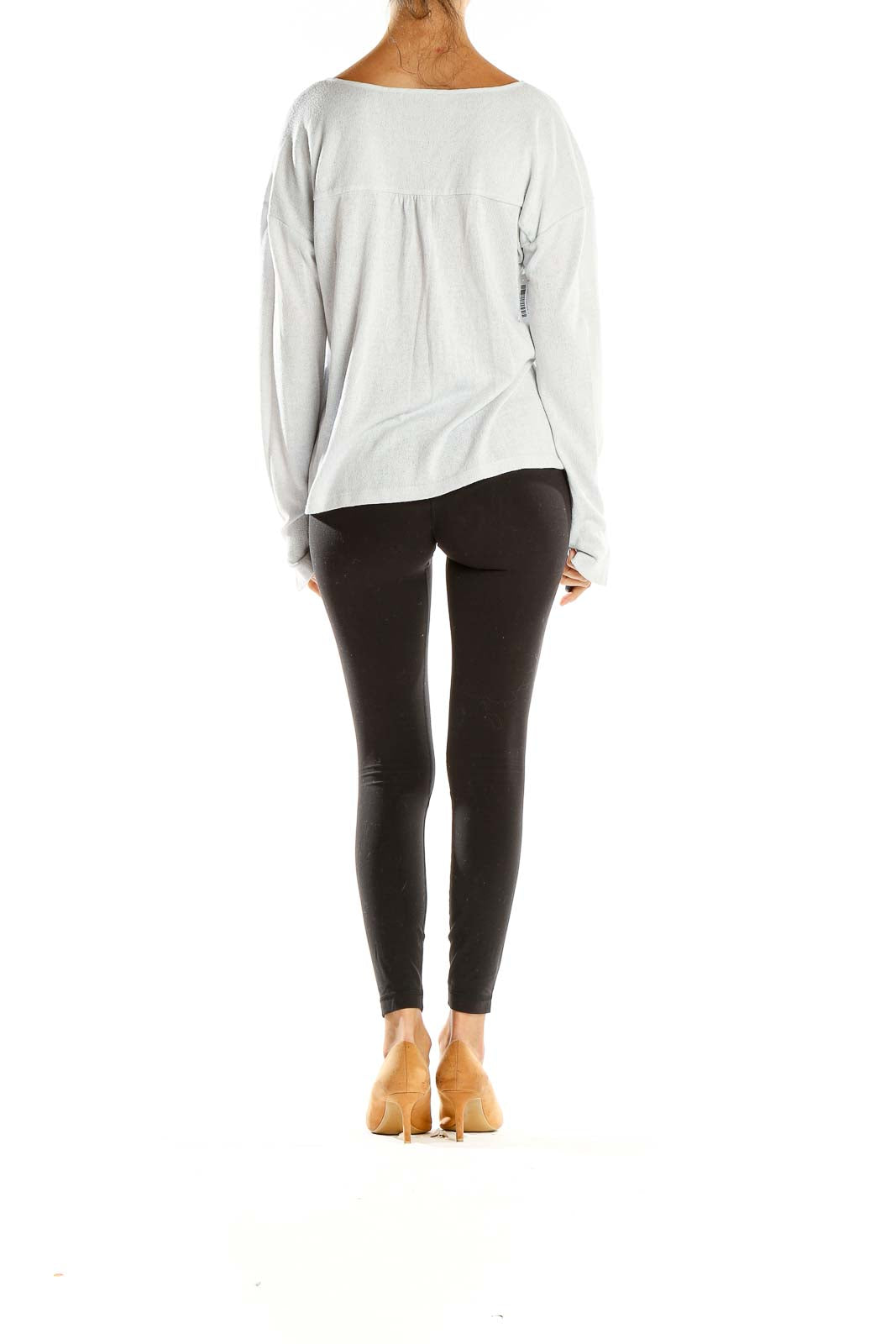 Side view of white V-neck long sleeve knit top by Sanctuary paired with black leggings