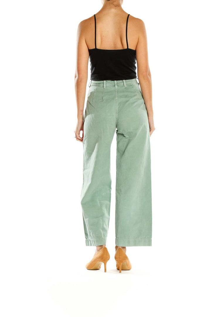 Side view of WE THE FREE sage green wide-leg pants on model with black top