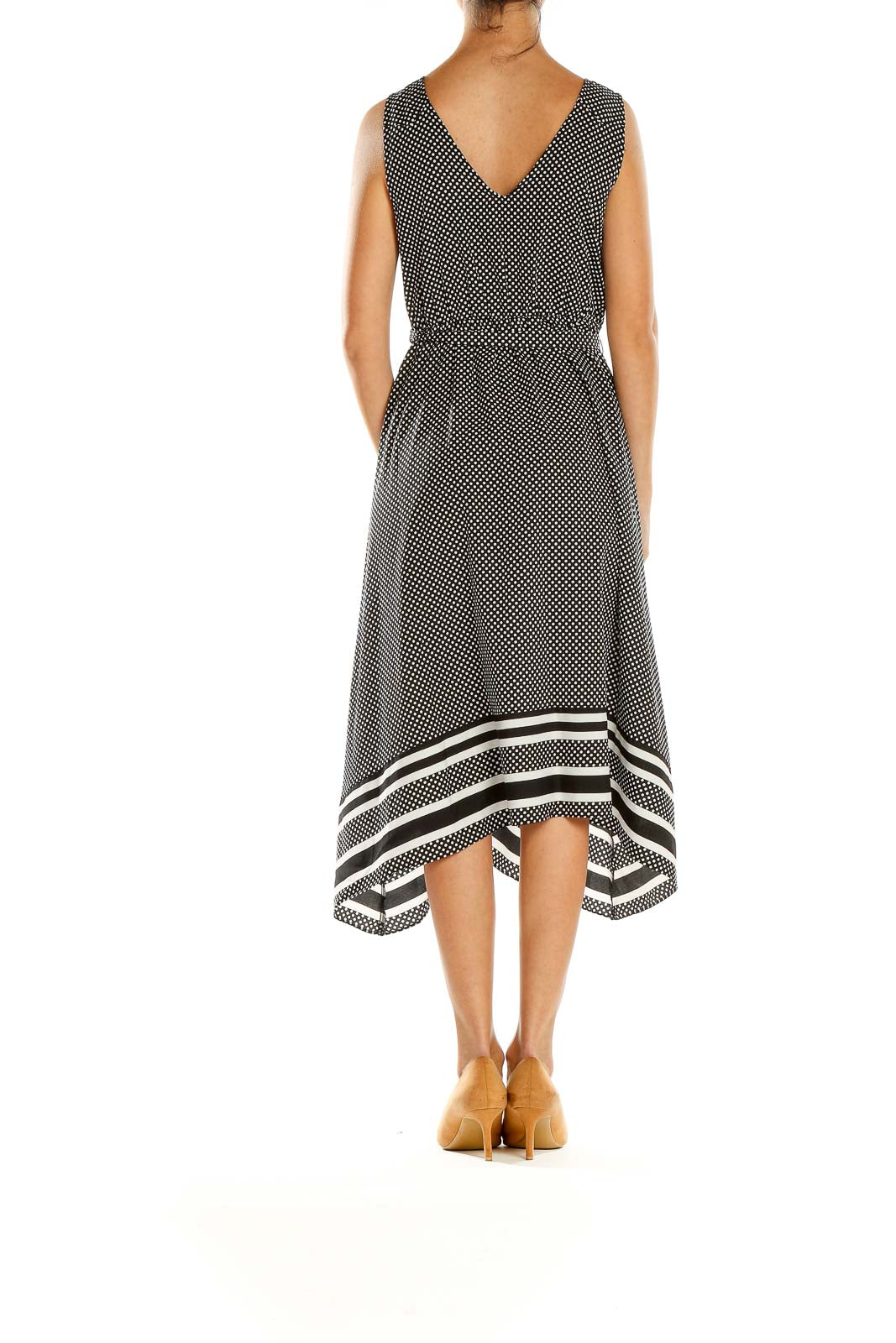 Side view of black polka dot maternity midi dress showing asymmetrical hem and striped border