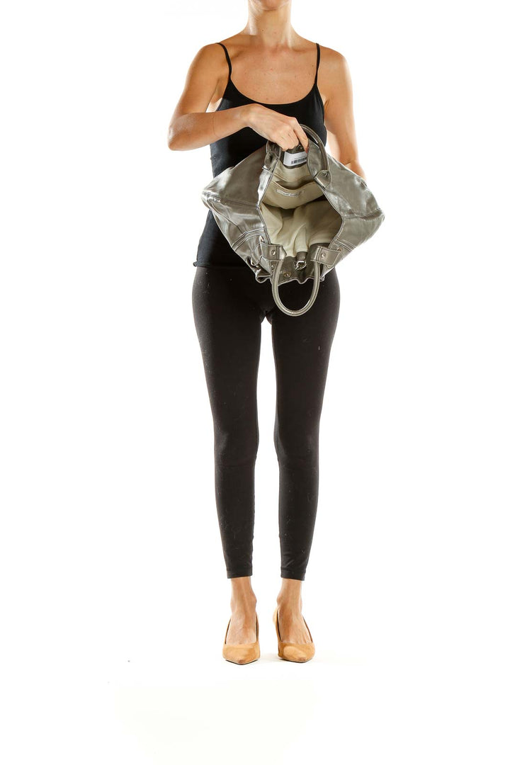Side view of woman carrying Nine West metallic gray hobo shoulder bag