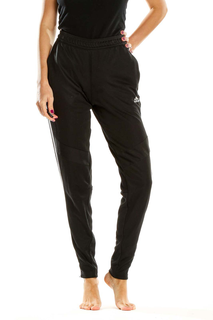 Front view of black Adidas track pants with white stripes