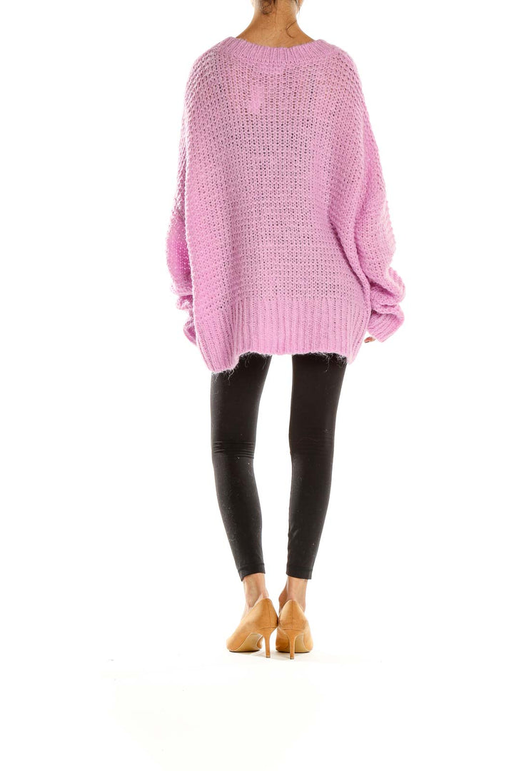 Side view of pink oversized chunky knit sweater by Chelsea28 paired with black leggings