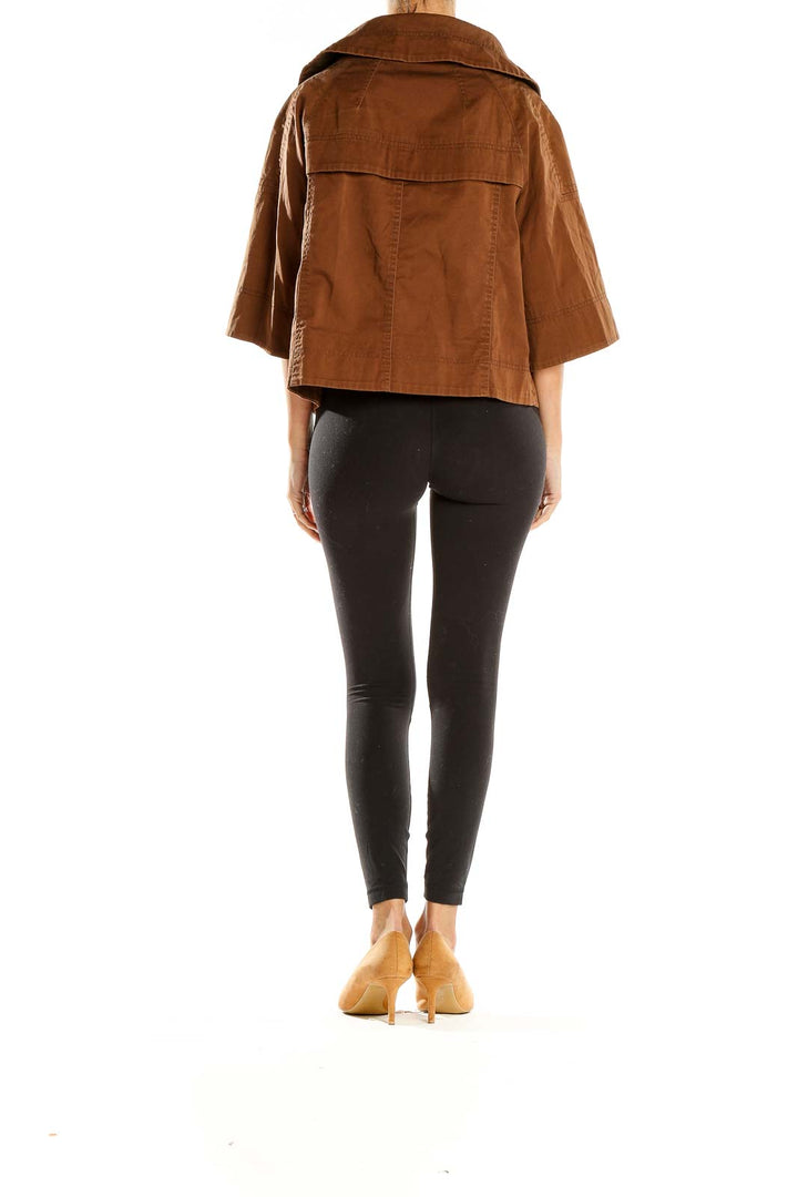 Side view of model wearing Carole Little brown cropped jacket
