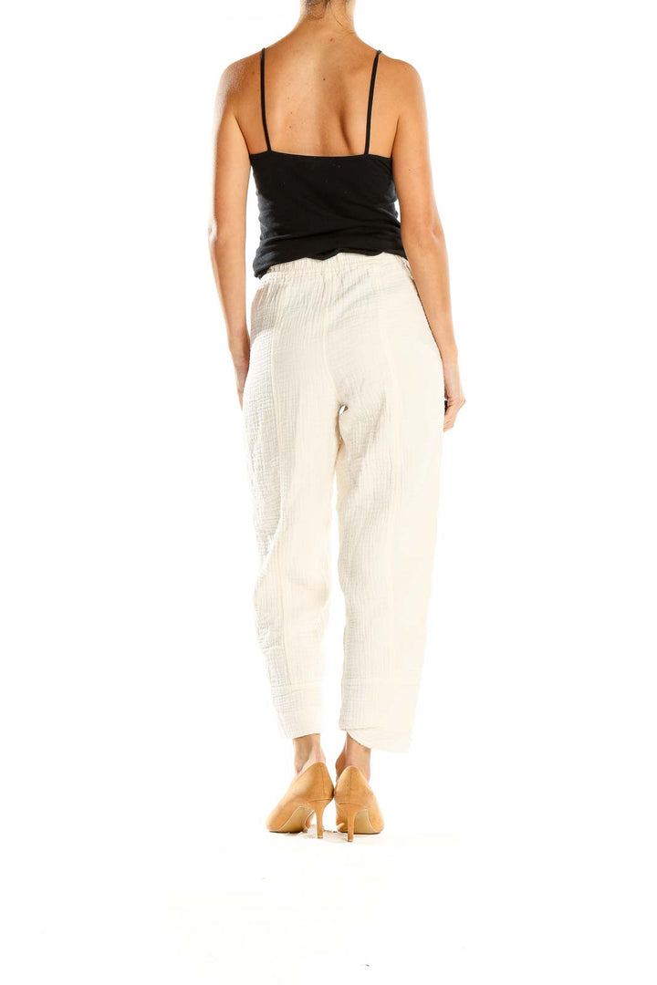 Side view of Madewell cream textured wide-leg pants on model with black top