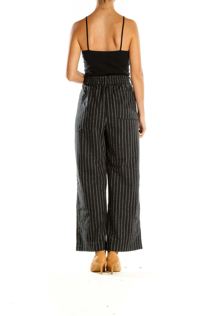 Side view of Wilfred gray pinstriped wide-leg trousers on model