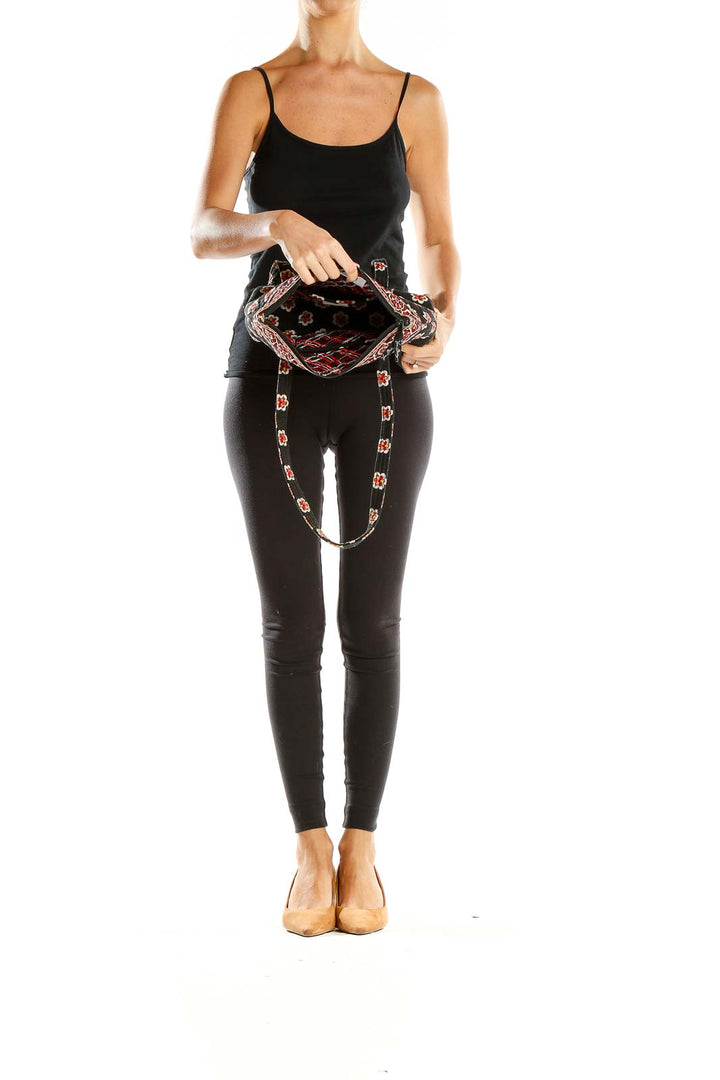 Side view of model carrying Vera Bradley black floral print shoulder bag