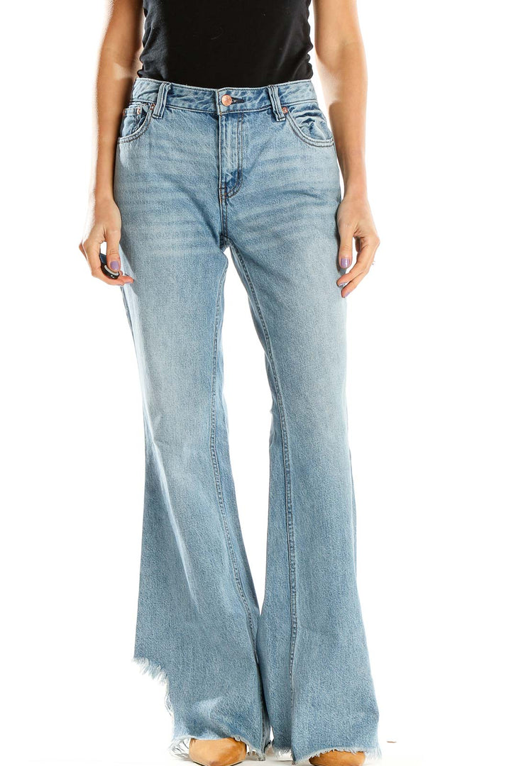 Front view of WE THE FREE light blue flared jeans with high waist and raw hems