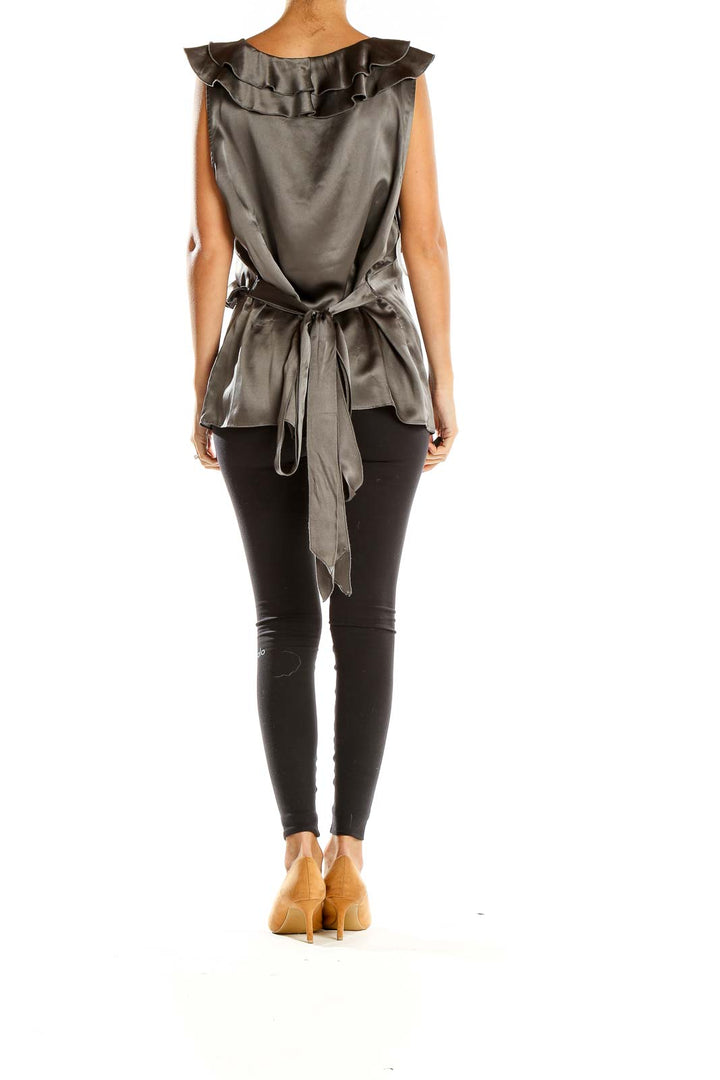 Side view of gray silk ruffled V-neck sleeveless top from Saks Fifth Avenue with black pants