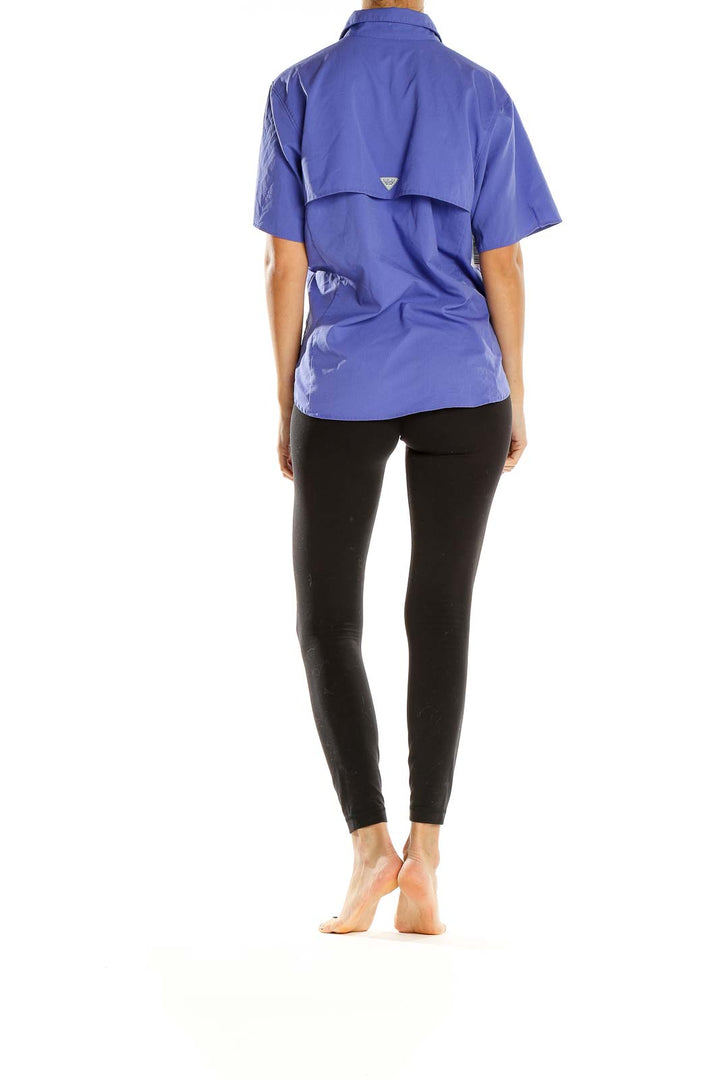 Side view of model wearing Columbia purple short-sleeve button-up activewear shirt with black leggings