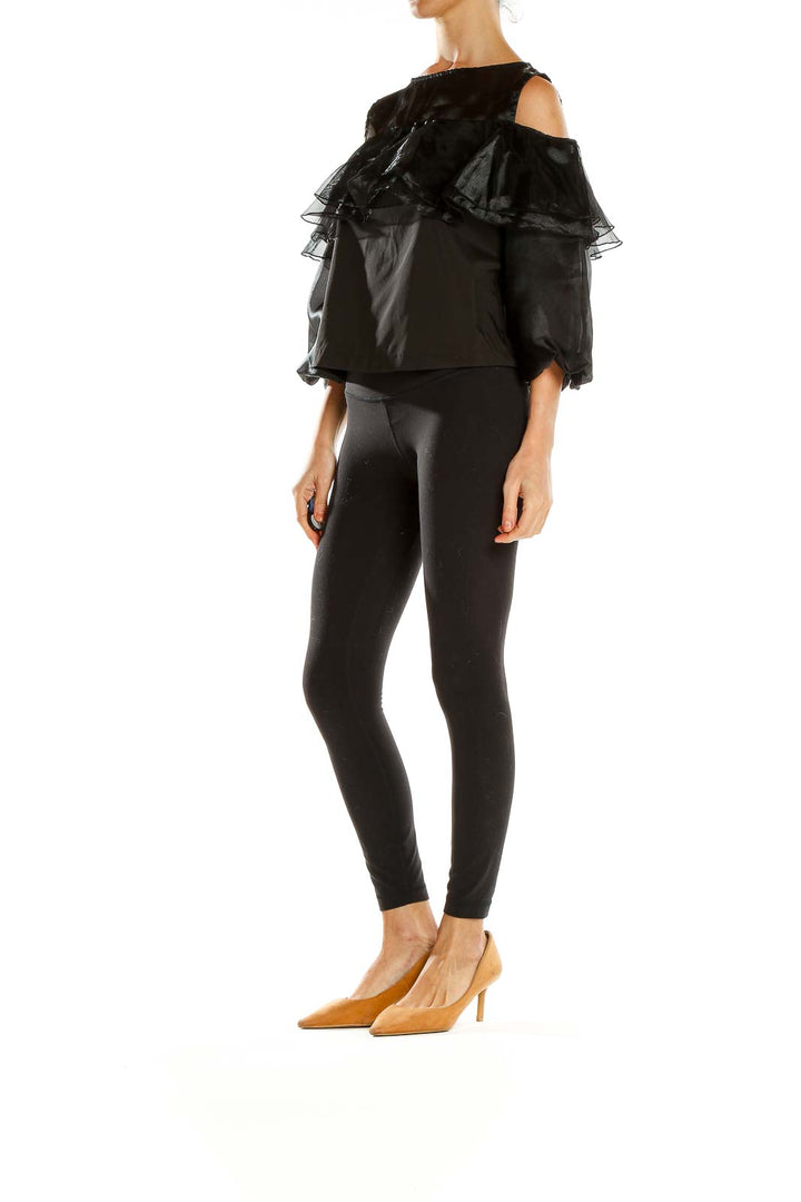 Front view of black ruffled cold-shoulder top by Twist x Turn