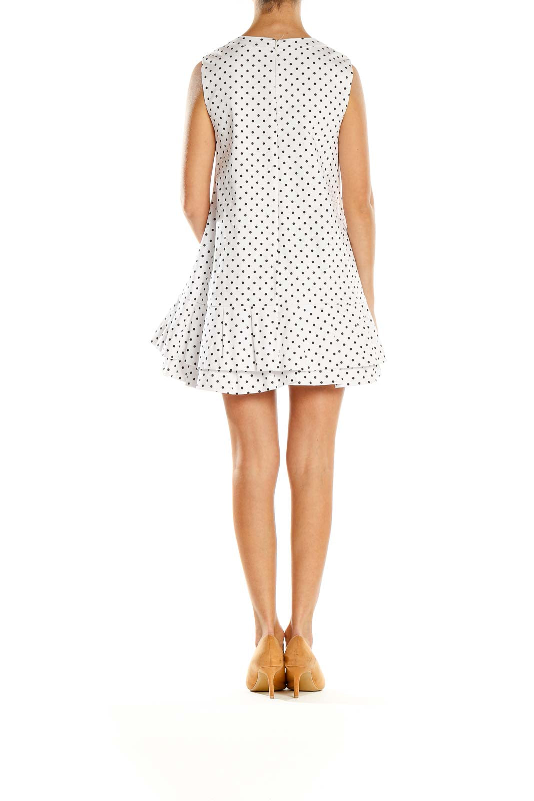 Side view of white polka dot sleeveless mini dress showing A-line silhouette