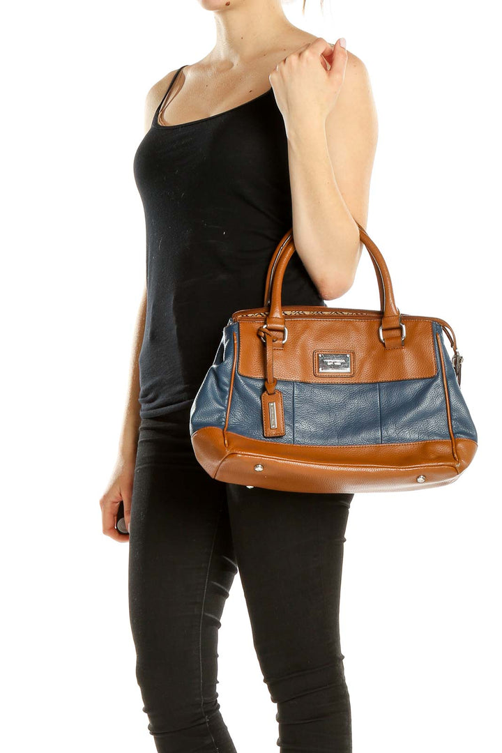 Front view of Tignanello brown and blue leather satchel held by hand
