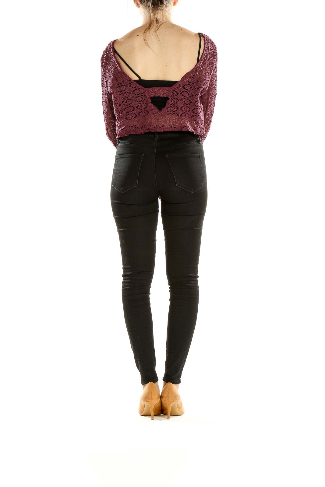 Side view of model wearing burgundy crochet crop sweater with black pants