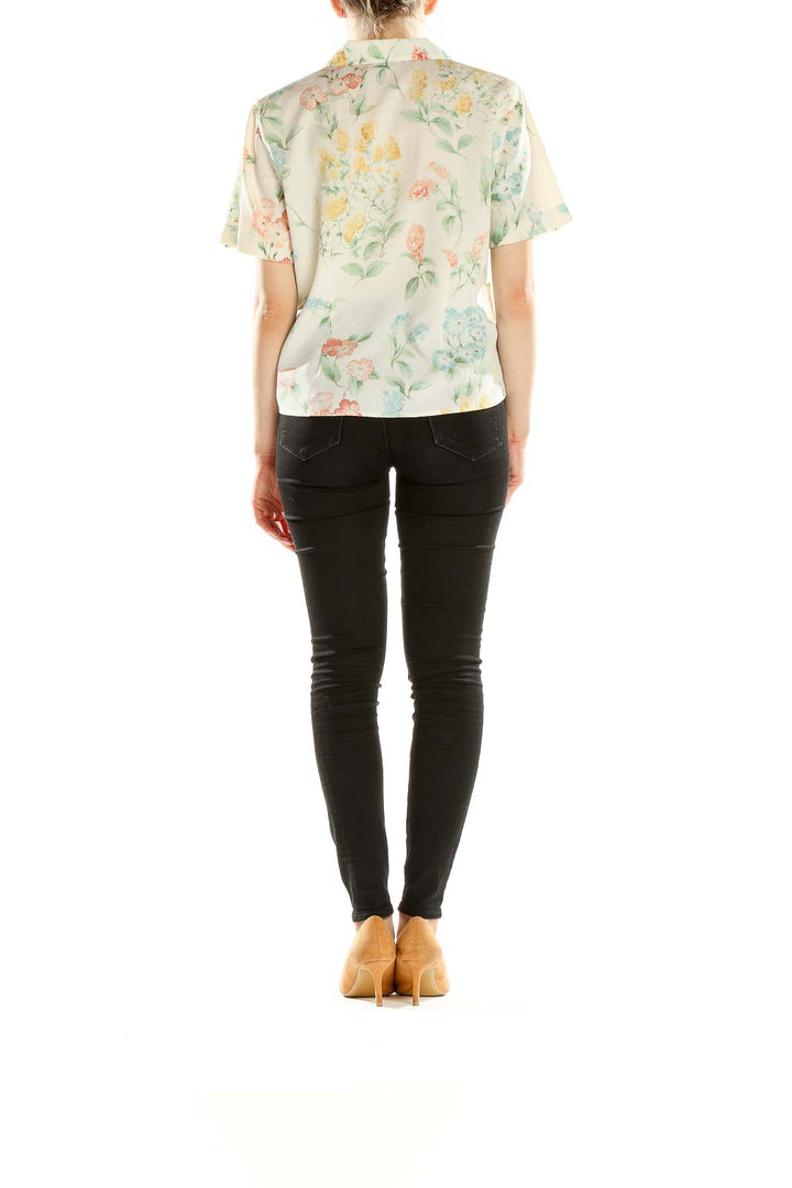 Side view of model wearing Alfred Dunner cream floral blouse with black pants