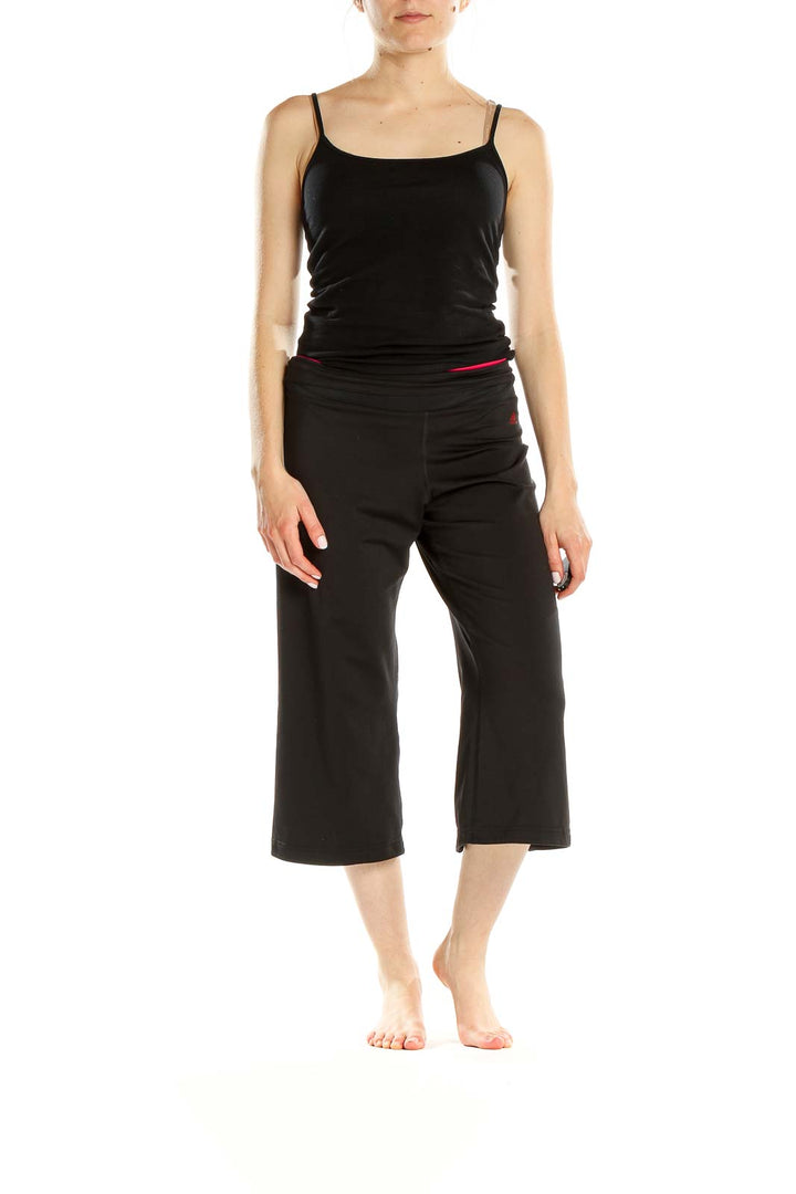 Front view of black Adidas capri yoga pants with red waistband accent