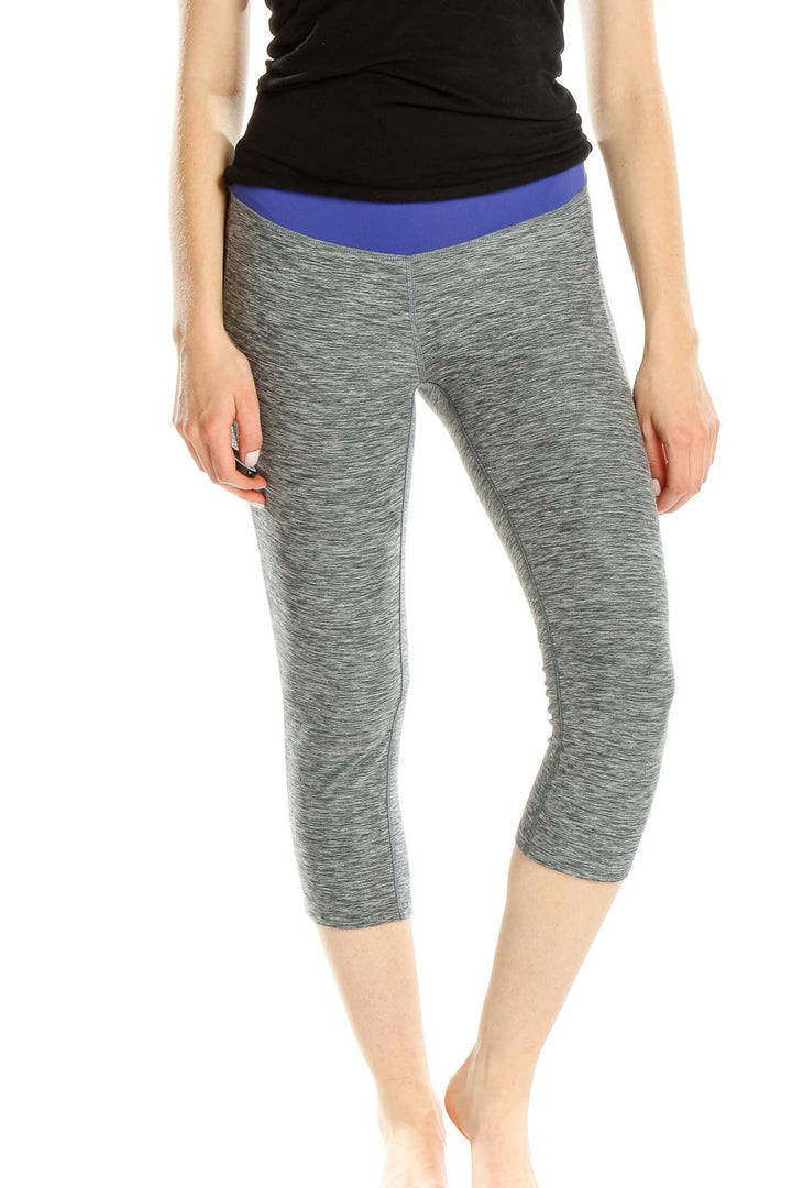 Front view of gray heathered New Balance capri leggings with blue waistband