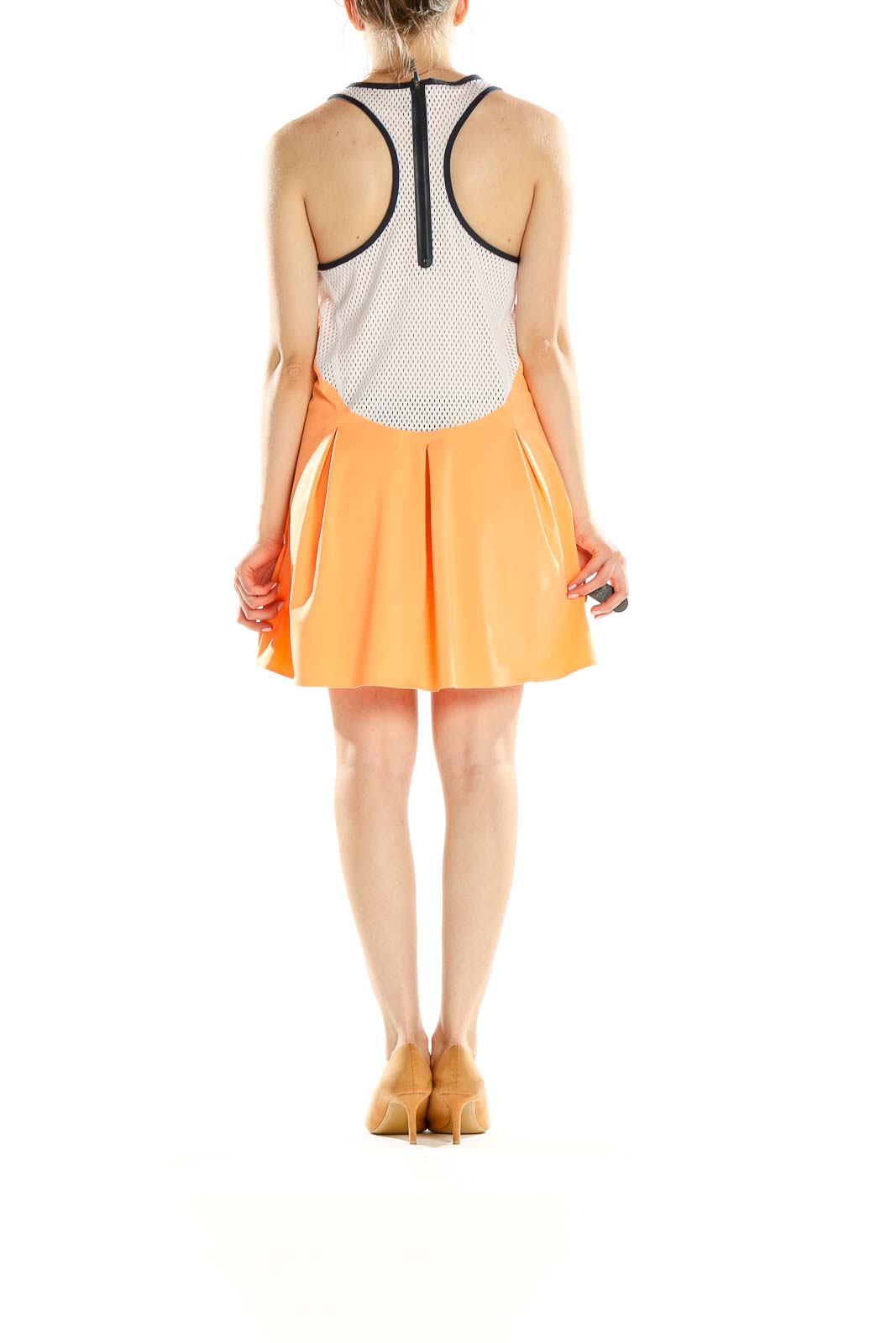 Side view of orange Nike pleated tennis dress showing mesh panels