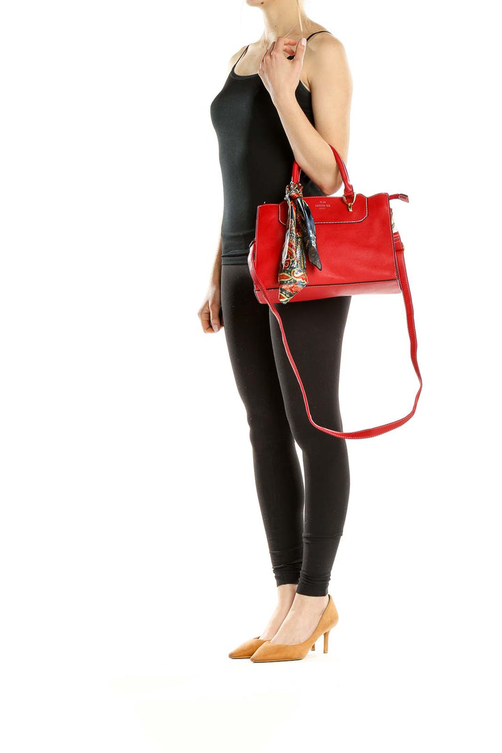 Front view of red leather London Fog crossbody bag with colorful scarf accent