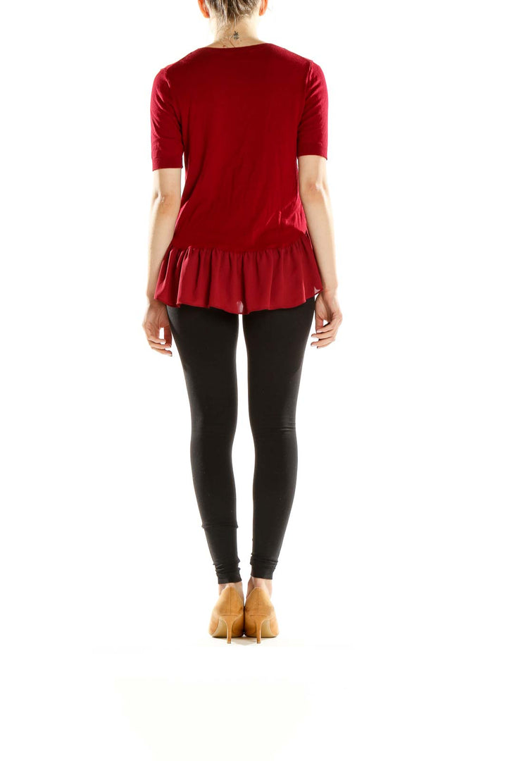 Side view of red peplum knit top from Ann Taylor LOFT with black pants
