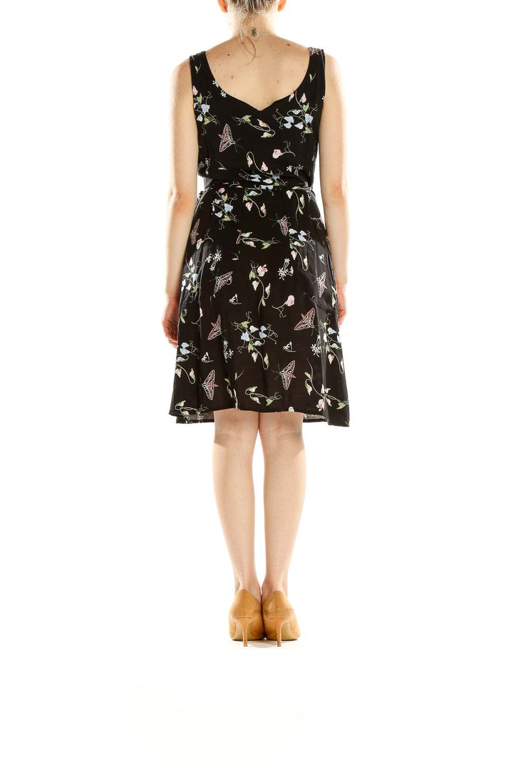 Back view of Field Day black sleeveless dress showing floral and butterfly pattern