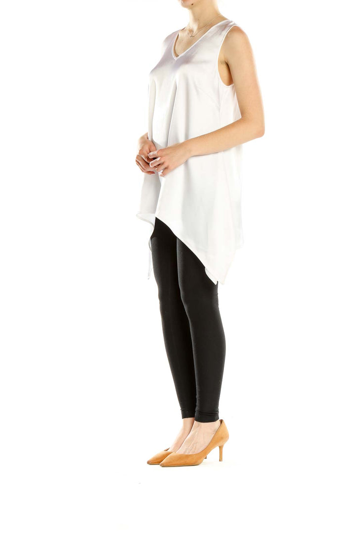 Front view of St. John Evening white sleeveless V-neck top with asymmetric hemline