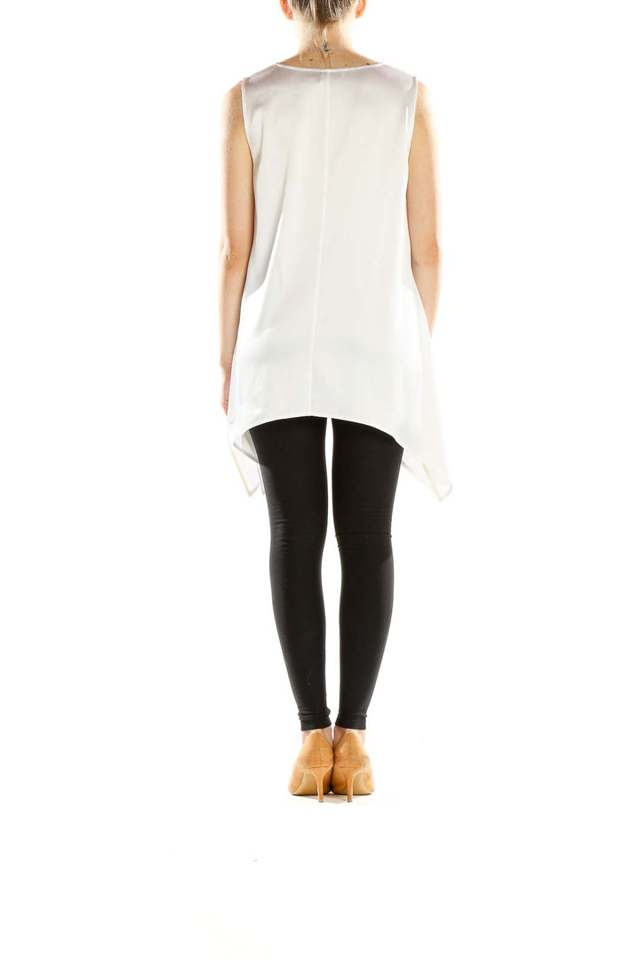Side view of St. John Evening white sleeveless top showing asymmetric hemline and fit