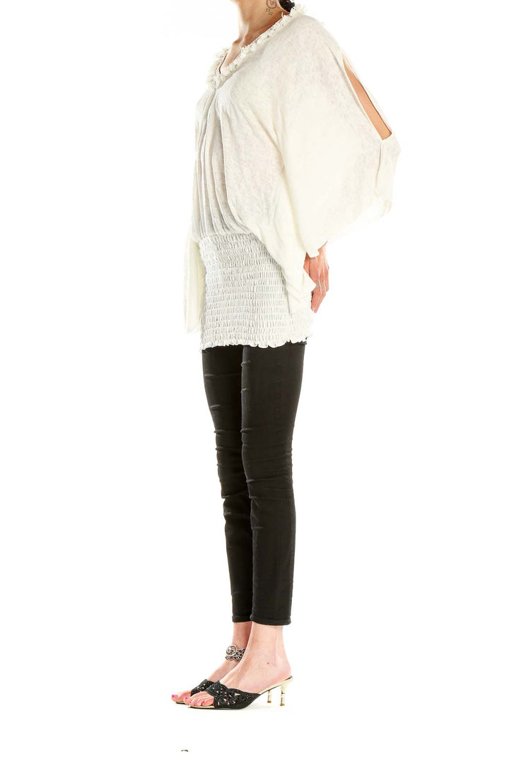 Front view of white fringe-trimmed tunic top with V-neckline and batwing sleeves