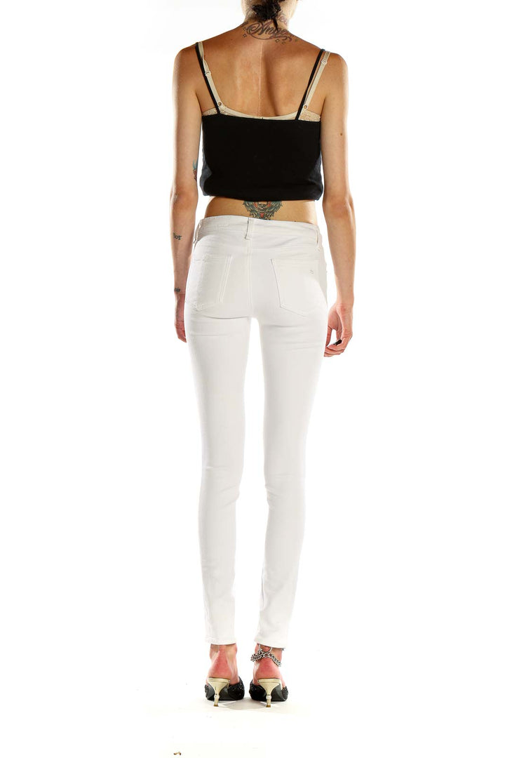Side view of Rag & Bone white skinny jeans on model with black top